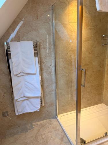 a shower with a towel on a towel rack at Porthole Suites in Saint Aubin