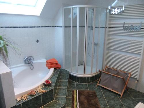 a bathroom with a bath tub and a shower at Villa Edelstein in Mörschied