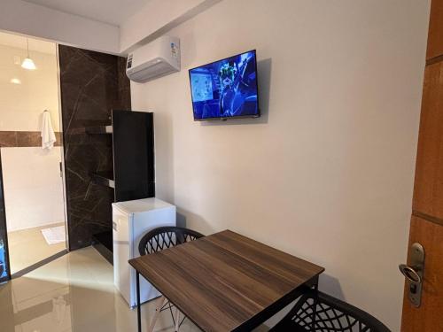 a room with a table and a television on the wall at Pousada Estalagem Da Serra in Serra do Cipo