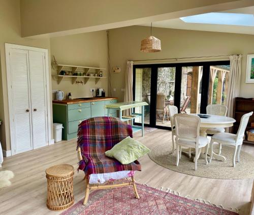 a living room with a table and chairs and a kitchen at Garden House Barmeath Castle in Grangebellew