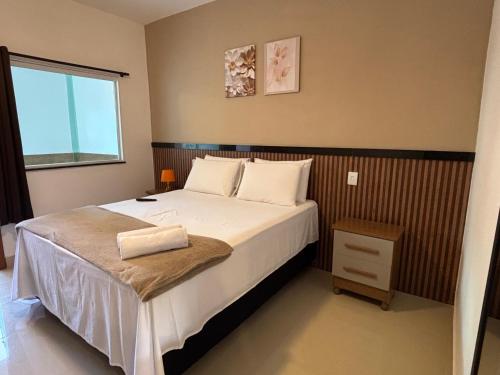 a bedroom with a large bed and a window at Pousada Estalagem Da Serra in Serra do Cipo