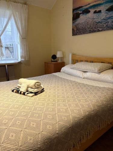 a bedroom with a bed with a blanket on it at Becontreelodge in Dagenham