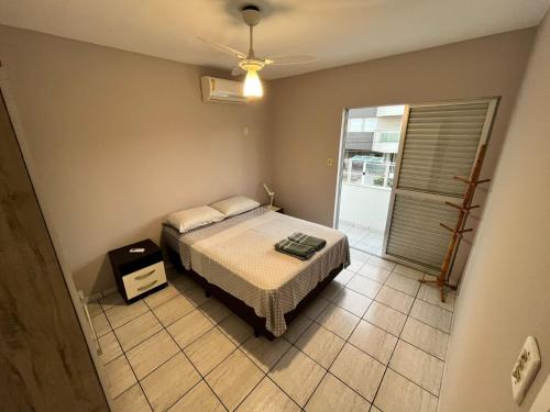 a bedroom with a bed and a window at Residencial Larissa Elena in Florianópolis