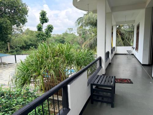 a balcony of a house with a bench on it at Royal Garden in Dambulla