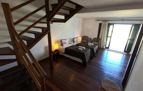 a living room with a bed and a staircase at Hotel Vila Marola in Taíba
