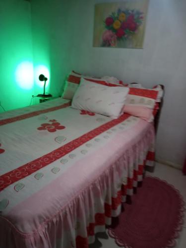 a bedroom with a bed with a red and white blanket at Recanto Aconchego in Torres