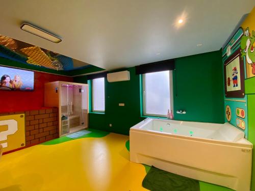 a bathroom with a tub in a room with green at Retro Gaming Mood - Arcade Games - Jacuzzi - Sauna - Switch 2 in Courcelles