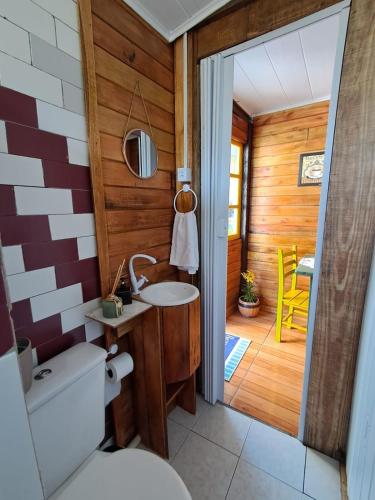 a bathroom with a toilet and a sink at Treehouse albatroz hospedaria in Imbituba