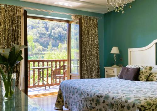 a bedroom with a bed and a balcony at Hotel Finca Malvasia - Adults only in Cabezón de Liébana