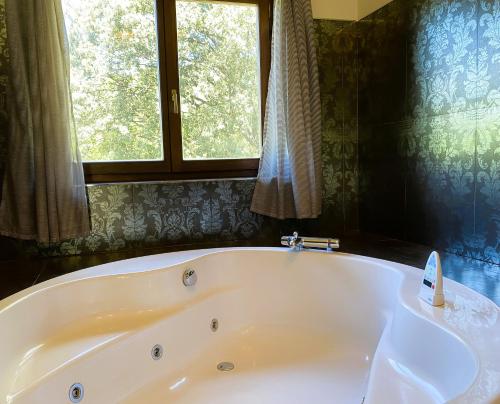 a bath tub in a bathroom with a window at Hotel Finca Malvasia - Adults only in Cabezón de Liébana
