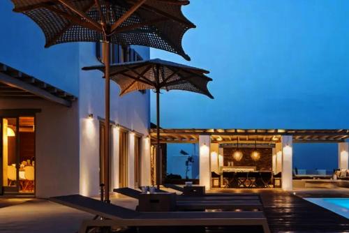 an outdoor patio with umbrellas and a pool at Ios sea view in Ios Chora