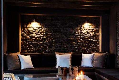 a living room with a couch and a stone wall at Ios sea view in Ios Chora