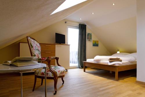 a attic bedroom with a bed and a chair at Das Weinberghaus in Fellbach