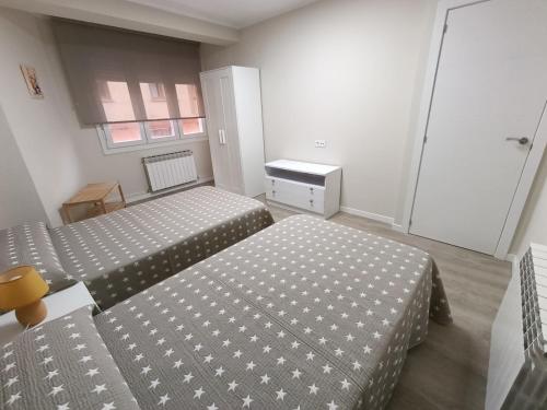 a hotel room with two beds and a window at VUT Montse in Alcañiz