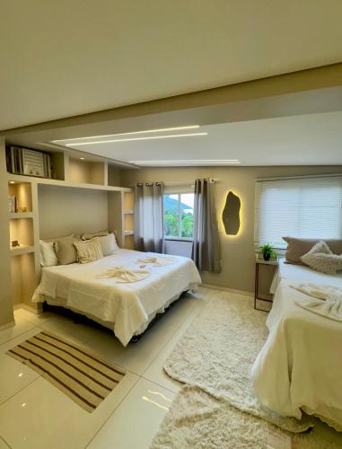 a large bedroom with two beds and a window at Boutique House - Ilha Grande in Abraão