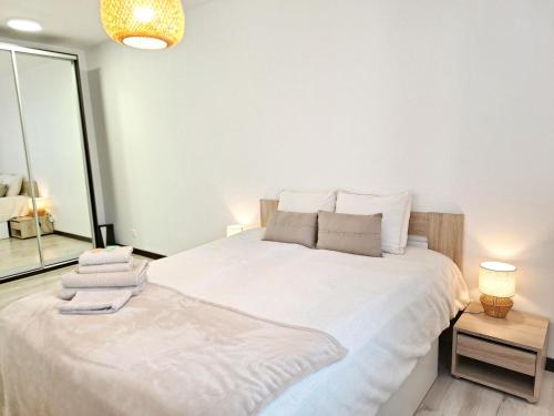 a large white bed in a room with a window at Kopų tako apartamentai in Melnragė