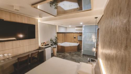 a bathroom with a bath tub and a television in a room at Paris Motel in Matão