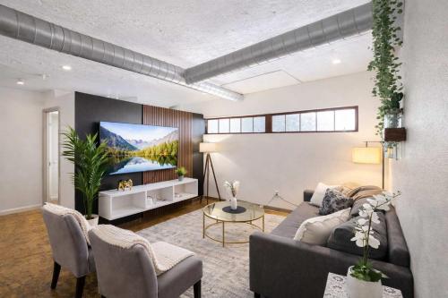 a living room with a couch and a tv at 2BR River Market Loft for 6 - Rooftop & Gym in Kansas City