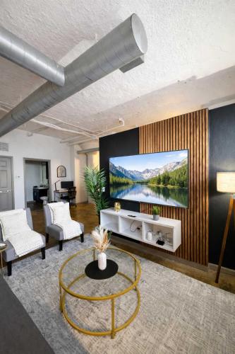 a living room with a flat screen tv on a wall at 2BR River Market Loft for 6 - Rooftop & Gym in Kansas City