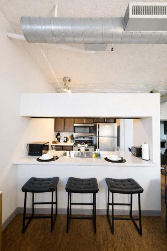 a kitchen with two stools and a counter in a room at 2BR River Market Loft for 6 - Rooftop & Gym in Kansas City