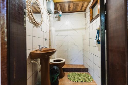 a small bathroom with a sink and a toilet at Green House Chalé, hostel e pousada in Saquarema
