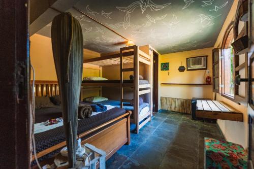 a dorm room with bunk beds and a desk at Green House Chalé, hostel e pousada in Saquarema