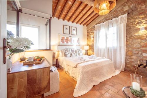 a bedroom with a bed and a stone wall at Chille in Capannori