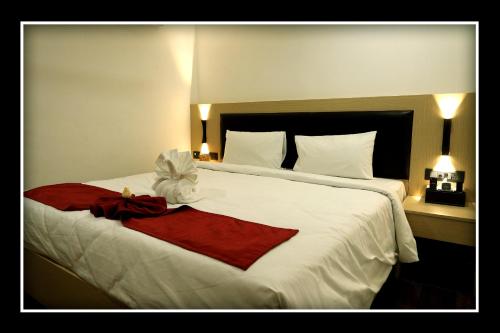 a large white bed with a red towel on it at Sri Sri Sri Excellency in Khammam