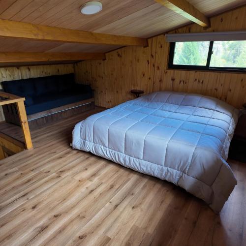 a bedroom with a bed in a wooden cabin at Premium Cabin in El Bolsón in El Bolsón