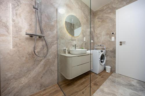 a bathroom with a sink and a washing machine at Apollo One, 1BR Signature Residence in Nivy