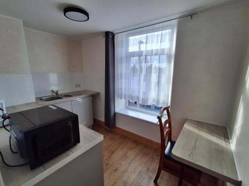 a small kitchen with a television and a window at The Albert Hotel in Gloucester