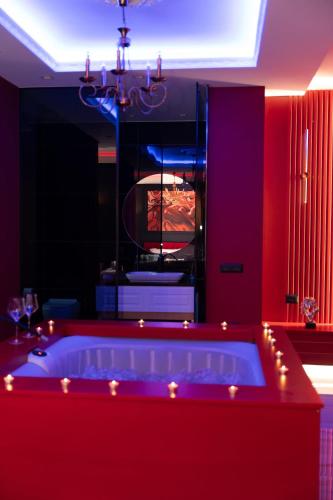 a red bathroom with a tub with lights in it at Luxury Love Suites in Elbasan