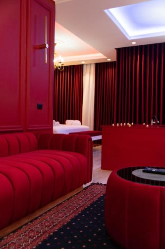a red living room with a couch and a bed at Luxury Love Suites in Elbasan