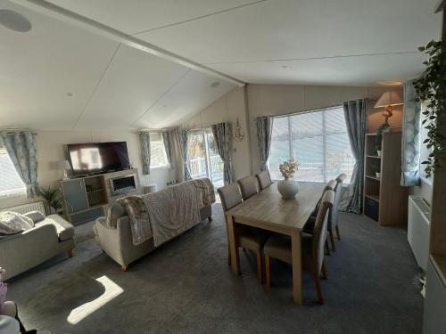 a living room with a table and a couch at Luxury Lakeview Lodge Chichester Lakeside Holiday Park in Chichester