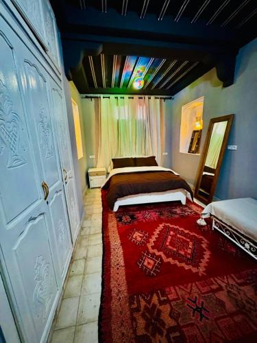 a bedroom with a bed and a red rug at Charmante Villa Traditionnelle in Marrakesh
