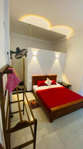 a bedroom with a red bed and a chair at Kanchi's please in Udawalawe