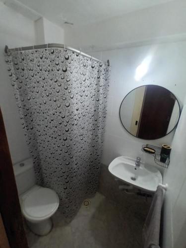 a bathroom with a toilet and a sink and a mirror at Casa Serena in Munro