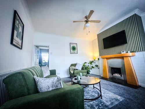 a living room with a couch and a fireplace at Worsley Gem, Modern 2BR with Garden Space in Worsley