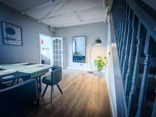 a dining room with a table and chairs and a staircase at Worsley Gem, Modern 2BR with Garden Space in Worsley