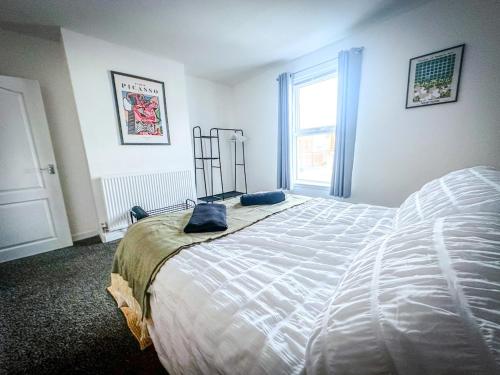 a bedroom with a large bed and a window at Worsley Gem, Modern 2BR with Garden Space in Worsley