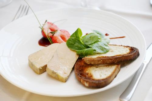 a plate of food with cheese and bread on a table at The Originals City, Hôtel Le Causséa, Castres in Castres