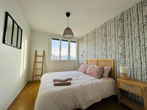 a bedroom with a large bed and a window at Appartement Bellevue - T2 vue montagne - calme - parking gratuit - 4 personnes in Meylan