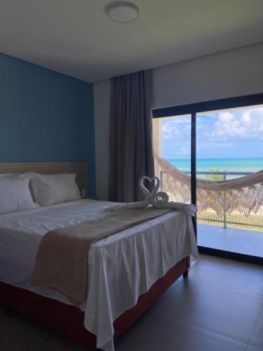 a bedroom with a bed with a view of the ocean at Maragogi Praia Hotel in Maragogi