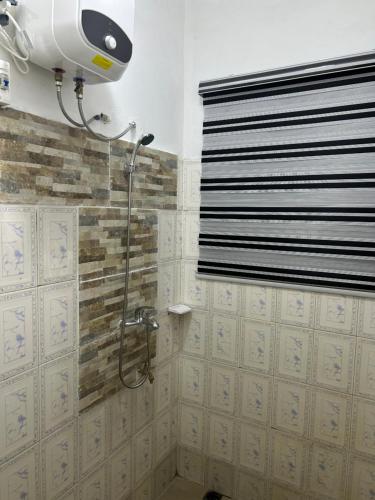 un bagno con doccia con soffione di Maison blanche a Cotonou