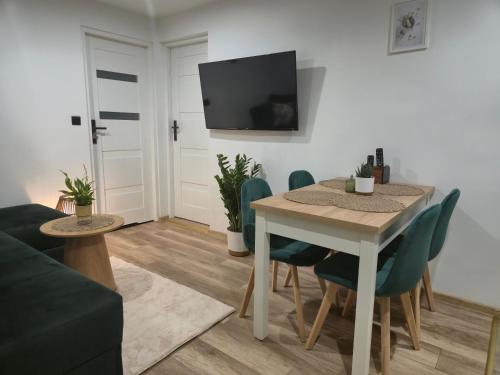 a living room with a table and chairs and a tv at Hortensjowe Zacisze in Wolibórz
