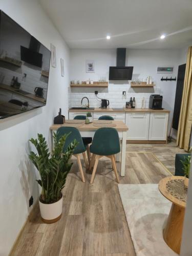 a kitchen with a wooden table and two chairs at Hortensjowe Zacisze in Wolibórz