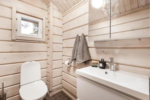 a bathroom with a white toilet and a sink at Villa Bear Den in Kittilä