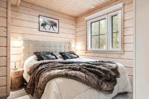a bedroom with a large bed in a wooden room at Villa Bear Den in Kittilä