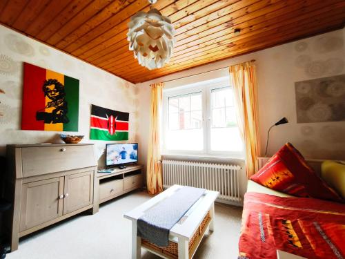 a living room with a couch and a chandelier at Hakuna Matata - Gemütlichkeit bei Oldenburg in Hatten