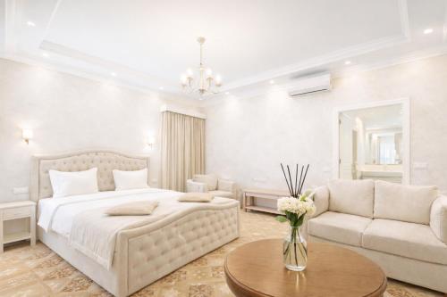 a bedroom with a bed and a couch and a table at Royal Renaissance Boutique by IGIT in Yerevan